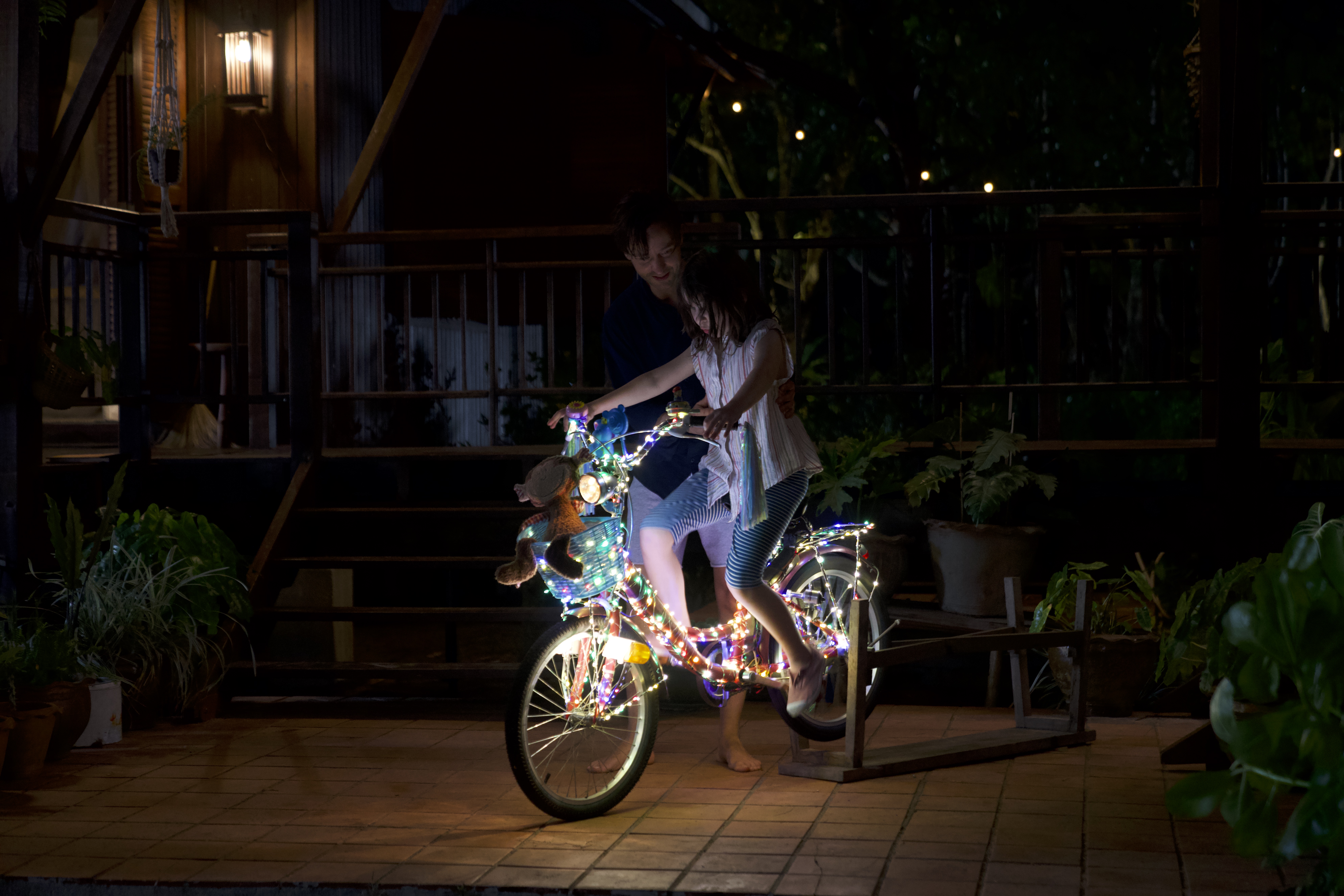 Standbild aus dem Film "Eine Milion Minuten": Wolf (Tom Schilling) bringt seiner Tochter Nina (Pola Friedrichs) auf ihrem neuen Leucht-Fahrrad, fahren bei.