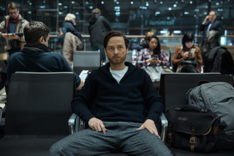 Standbild aus dem Film "Eine Milion Minuten": Wolf Küper (Tom Schilling) sitzt frustriert am Flughafen.