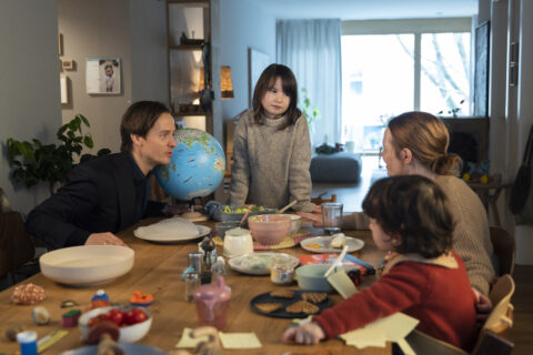 Standbild aus dem Film "Eine Milion Minuten": Familie Küper sitzt am Esstisch. Ein Globus steht am Tisch, wo wird die Reise hingehen?