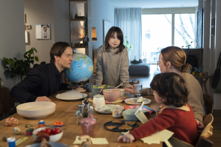 Standbild aus dem Film "Eine Milion Minuten": Familie Küper sitzt am Esstisch. Ein Globus steht am Tisch, wo wird die Reise hingehen?