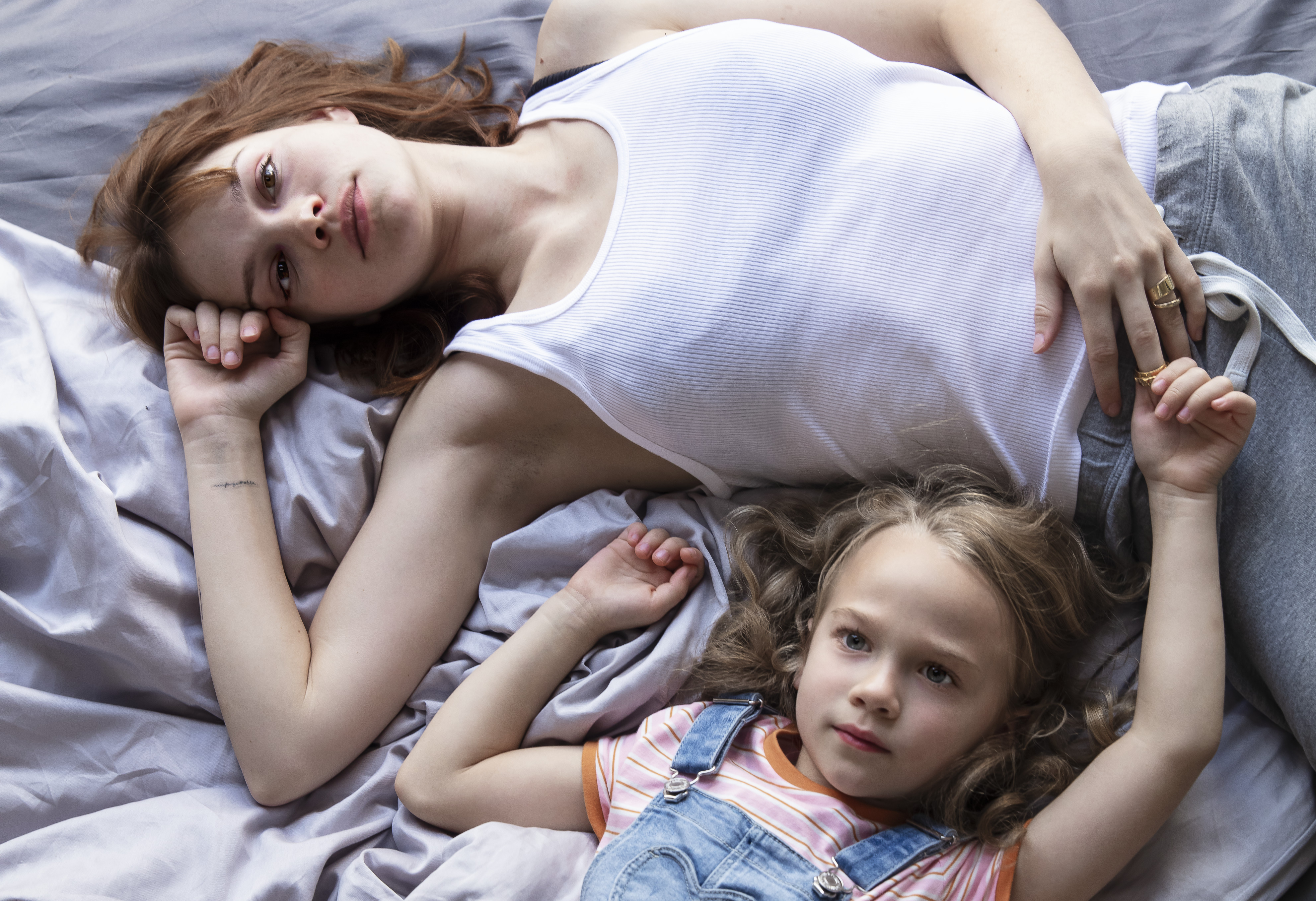Standbild aus dem Film "Wunderschön": Julie (Emilia Schüle) und Toni (Luna Arwen Krüger) liegen nachdenklich im Bett.